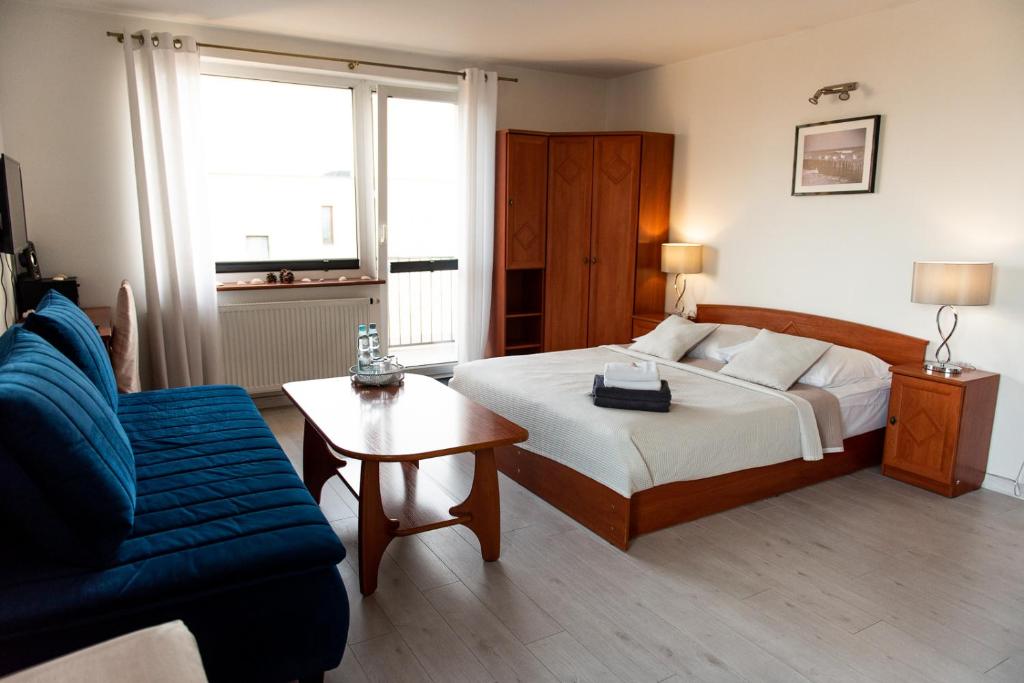 雷瓦Villa Plazowa 6的一间卧室配有一张床、一张沙发和一张桌子