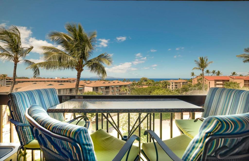 基黑Maui Vista 3406 - Ocean View Penthouse Sleeps 7的阳台配有桌椅和棕榈树