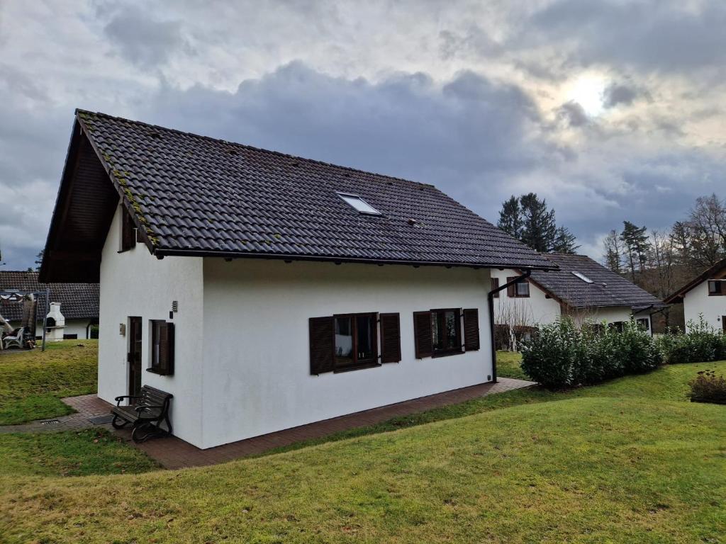 基希海姆Ferienhaus im Seepark von Kirchheim的黑色屋顶的白色房子