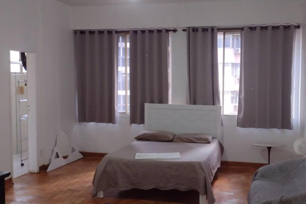 圣保罗Apartamento 74 Consolação Centro的一间卧室设有一张床和两个窗户。