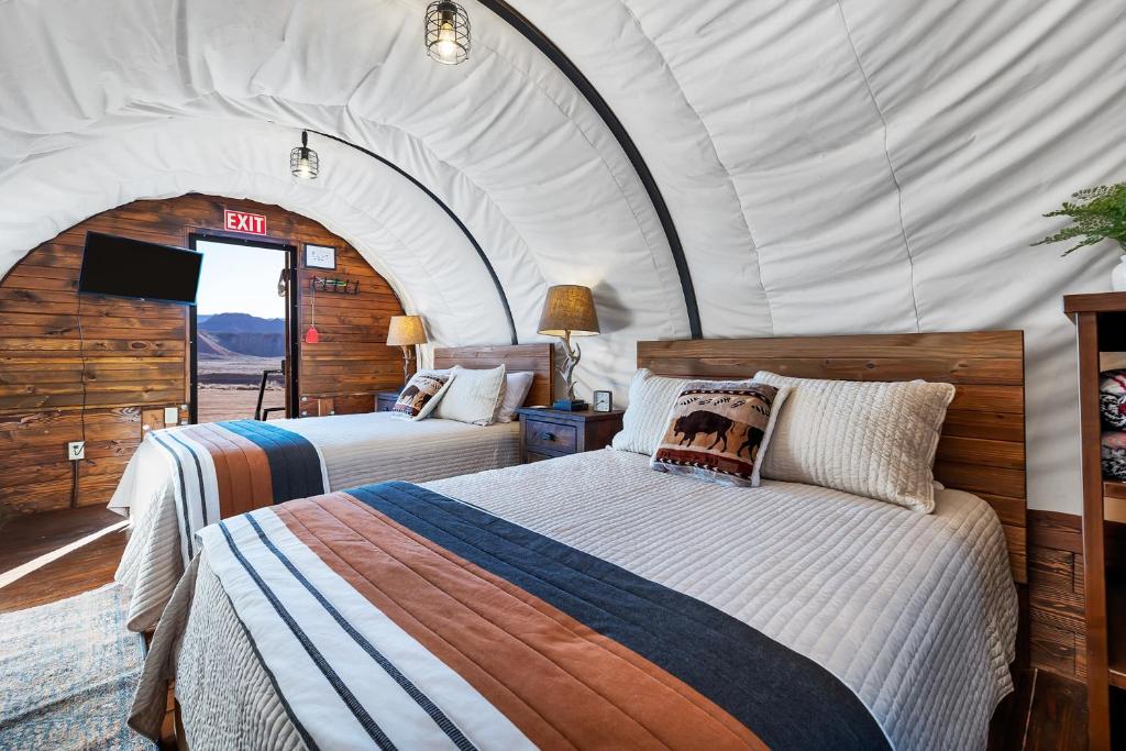 维尔京Zion White Bison Glamping & RV Resort的一间帐篷内带两张床的卧室