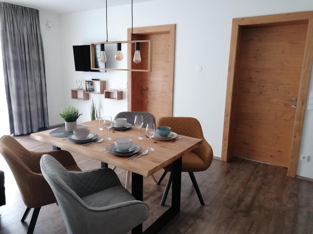 施图拜河谷新施蒂夫特Appartements Kleeblatt的一间带木桌和椅子的用餐室