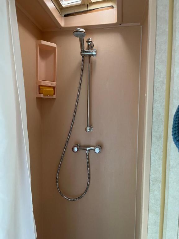 斯塔沃洛La caravane de Maminou的浴室门上设有软管淋浴