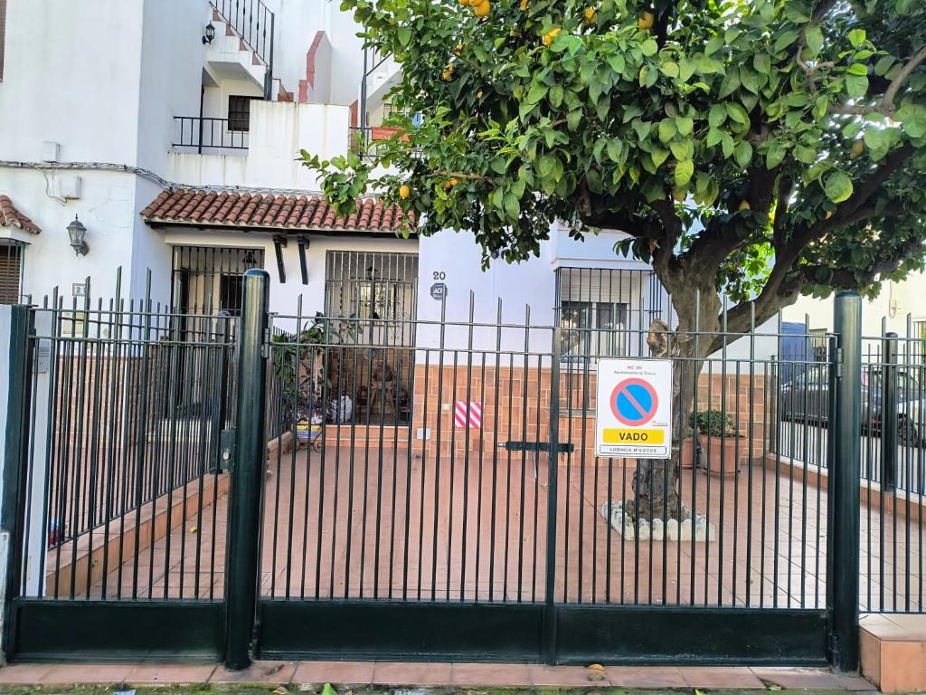塞维利亚Casa El limonero的房屋前有树的栅栏