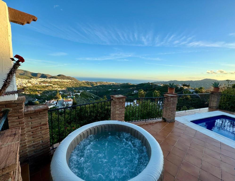 弗里希利亚纳Villa en Frigiliana con piscina, jacuzzi y espectaculares vistas的房屋阳台的热水浴池