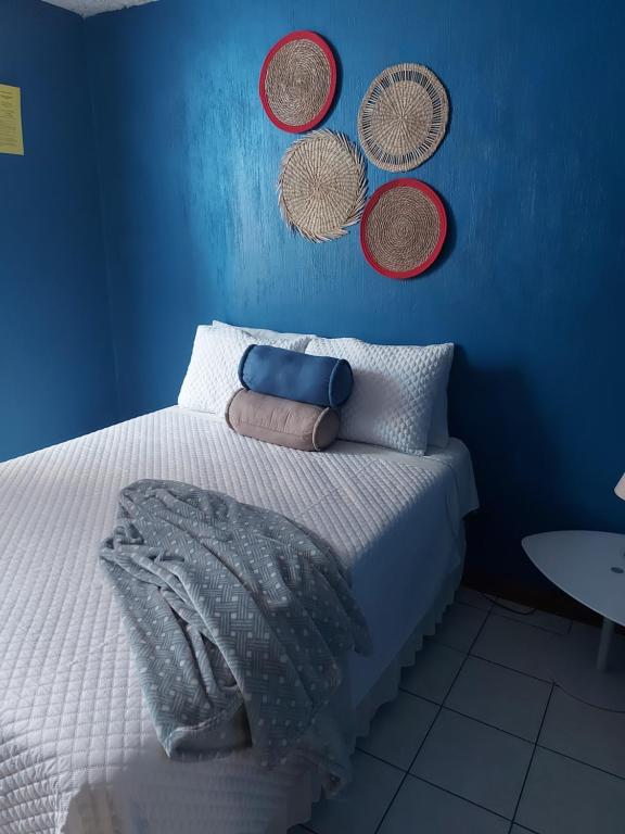 危地马拉Casa familiar La Arboleda的蓝色的卧室,配有一张挂在墙上的带篮子的床