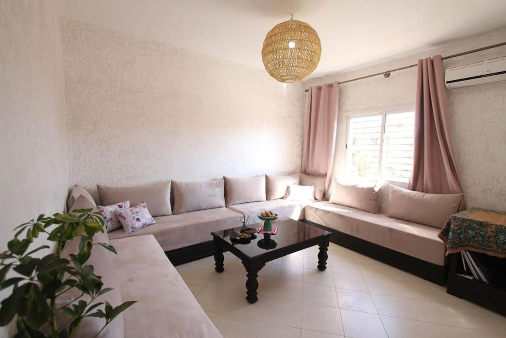马拉喀什appartement confort calme propre的客厅配有沙发和桌子
