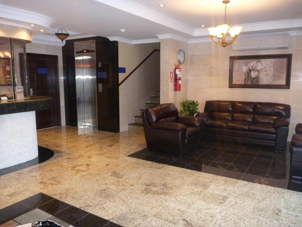 巴拿马城艾尔阿曼内瑟之家酒店的大堂设有真皮沙发和酒吧