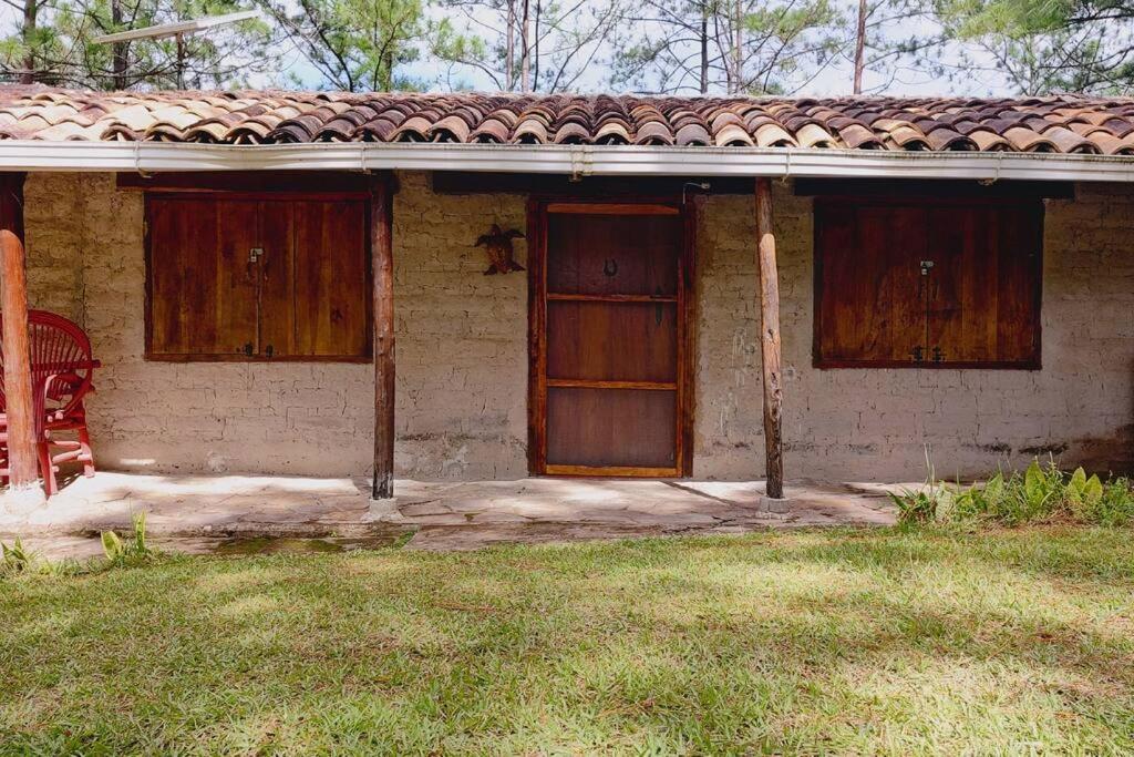 SiguatepequeCabaña La tortuga的两扇木门和草地庭院的房子