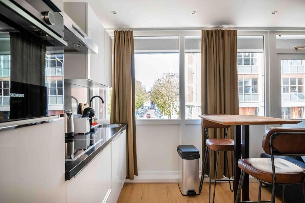 鹿特丹Apartment Heart of Rotterdam的厨房配有柜台、桌子和窗户