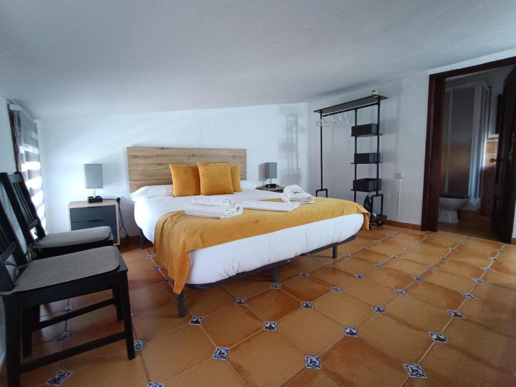 乌贝达La Casita的一间卧室配有一张大床和一把椅子