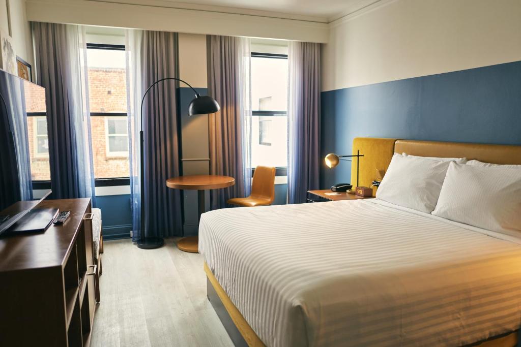 旧金山Hotel Julian的酒店客房设有一张床、一张书桌和窗户。