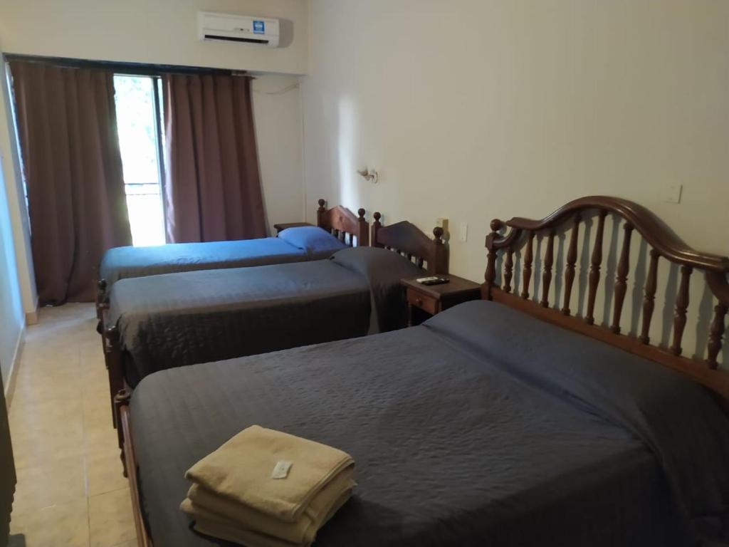 布宜诺斯艾利斯Hotel Manzanares Plaza的一间酒店客房,房间内设有三张床