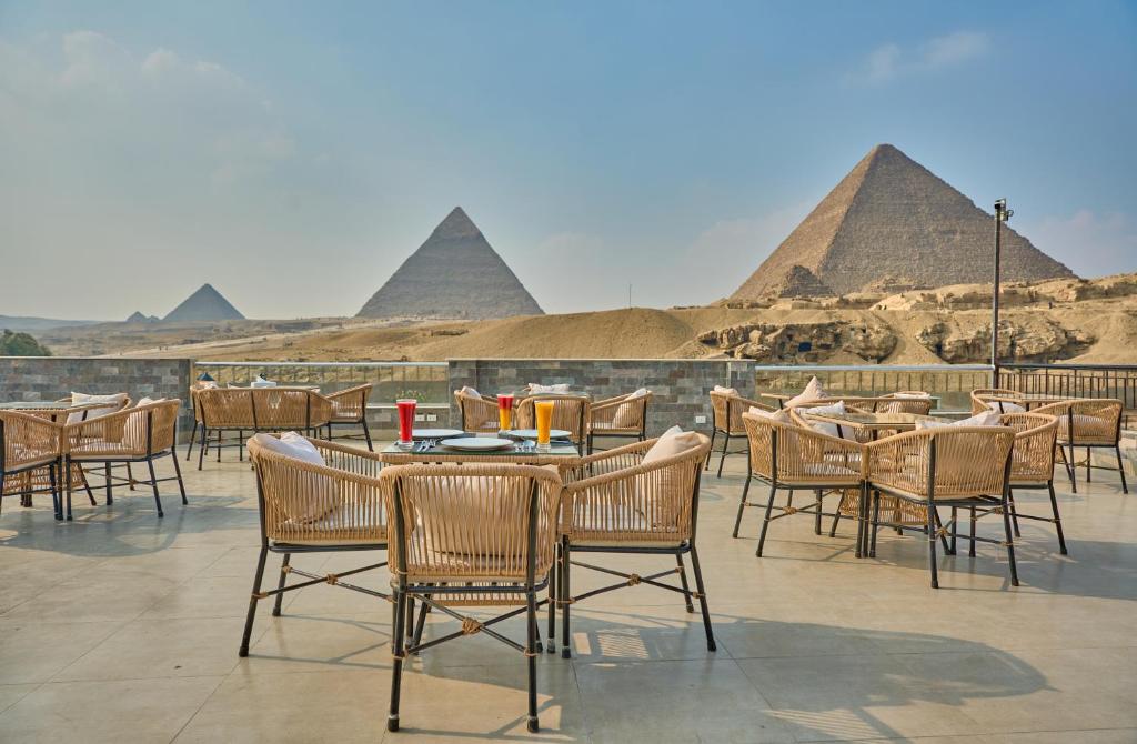 开罗Soul Pyramids View的餐厅设有桌椅,以金字塔为背景