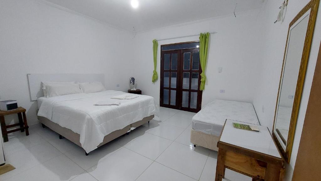 伊比科阿拉Residencial Maria de Lourdes的白色的卧室设有床和窗户