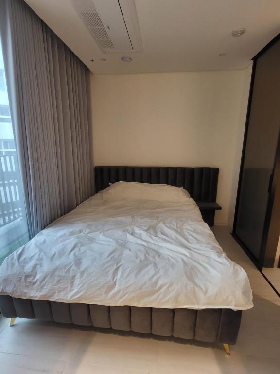 首尔Domus的一张大床,位于带大窗户的房间里