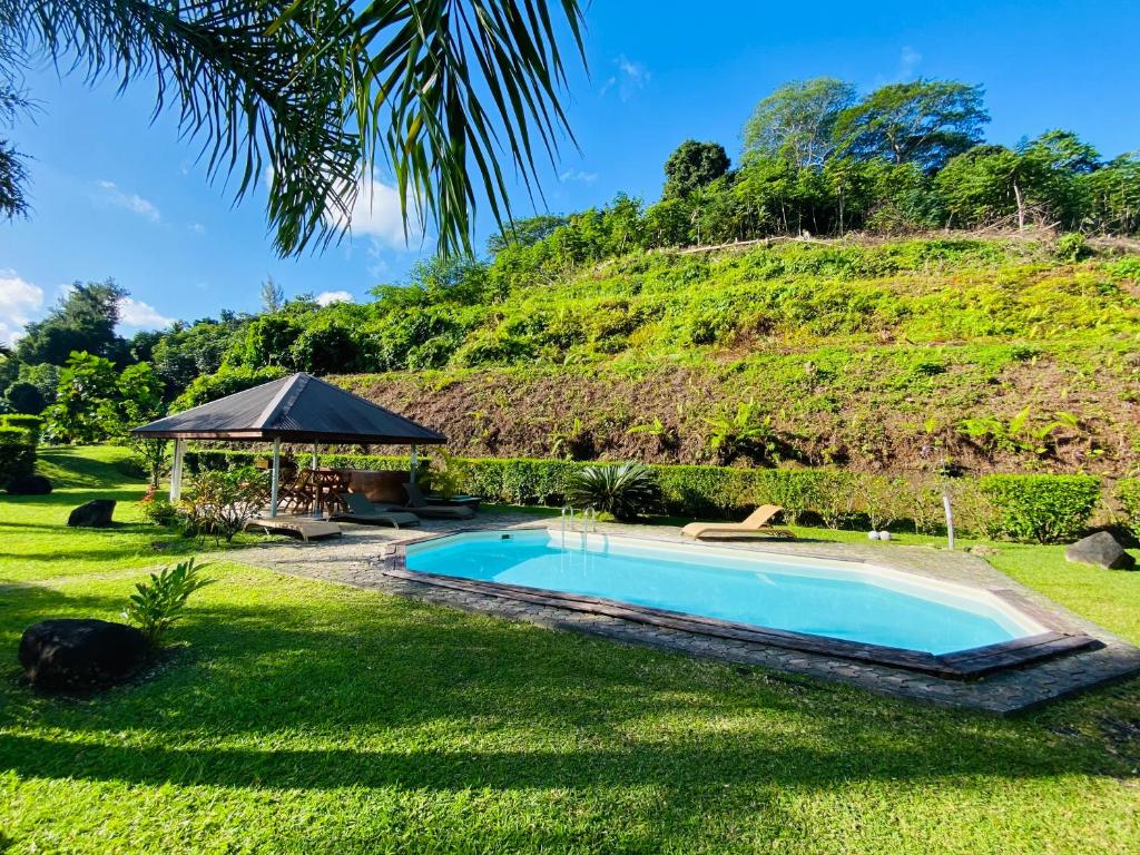 乌图罗阿Bungalow Tiare的一座位于庭院内的游泳池,山丘位于酒店后面