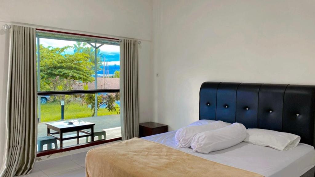 RatodenaAmadeo Guest House的一间卧室设有一张床和一个大窗户