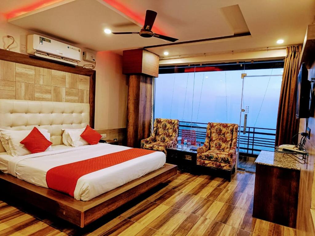 达兰萨拉Hotel King Castle Central Heated & Air cooled的一间卧室配有一张床和两把椅子,并设有一个阳台