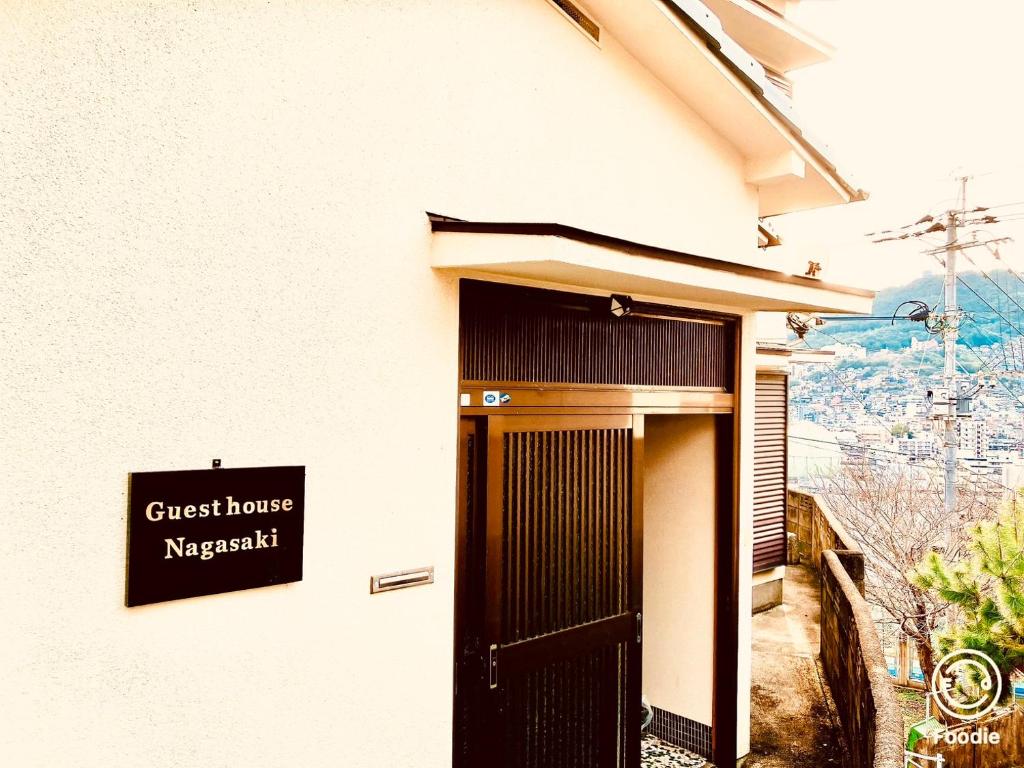 长崎Guest House Nagasaki 2 御船蔵の我が家 2的大楼一侧的卡帕奇标志旅馆