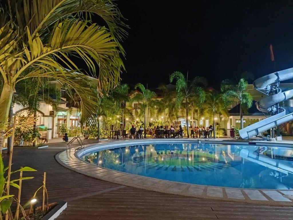 巴旺Marand Resort -Highway的一座晚上有人围坐在泳池周围的游泳池