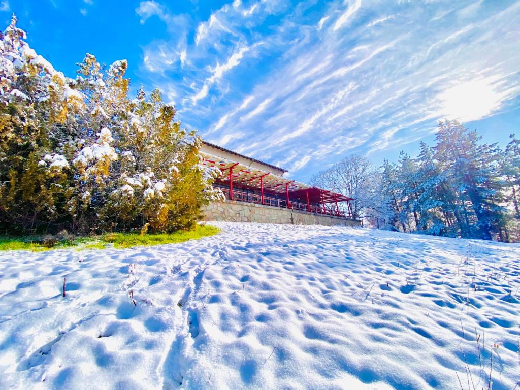 哈斯科沃Хижа Манастирчето-Книжовник的一座有雪盖的田野,后面有一座建筑