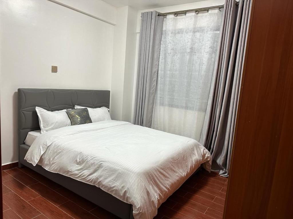 内罗毕Home Croft Nairobi的一间卧室设有一张大床和窗户