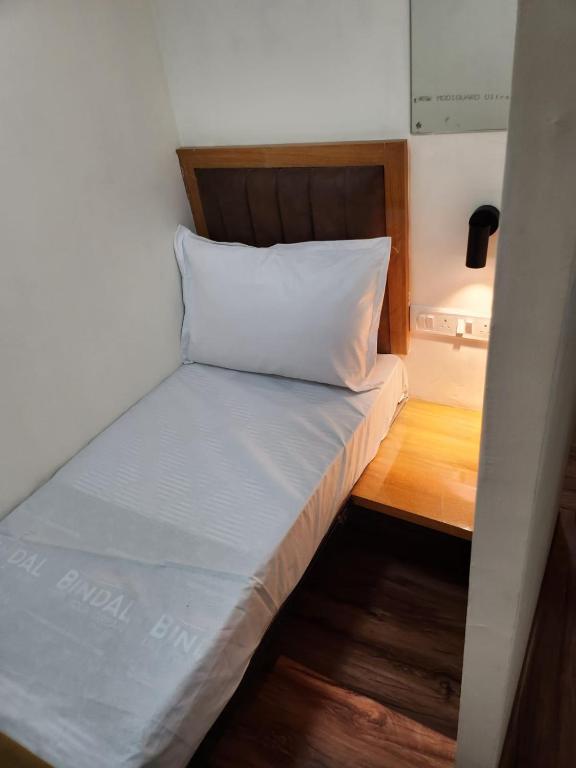 孟买Galaxy Cabin Stay And Dormitory的一个小房间里一张床铺,上面有枕头