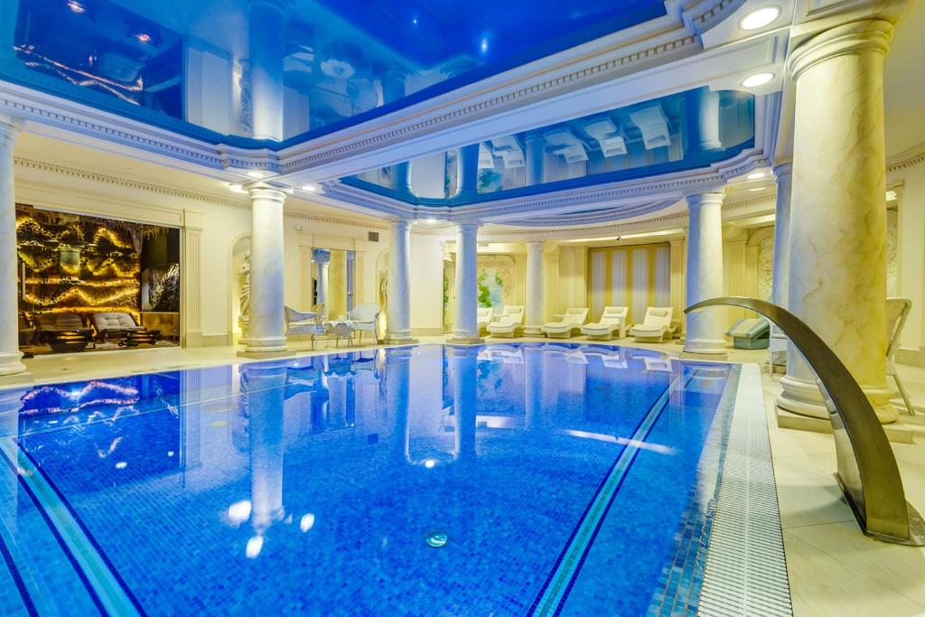 Otrębusy帕拉克奥措布斯商务及Spa酒店的大型客房的大型游泳池,设有大型建筑