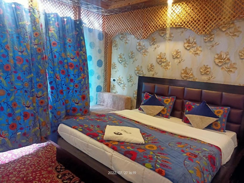 斯利那加Hotel Kashmir Heaven的一间卧室配有蓝色和红色窗帘的床