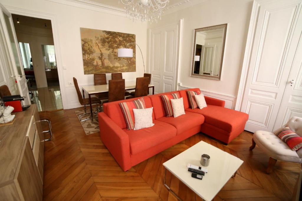 里昂拉斯特兰特瑞尼公寓的客厅配有红色的沙发和桌子