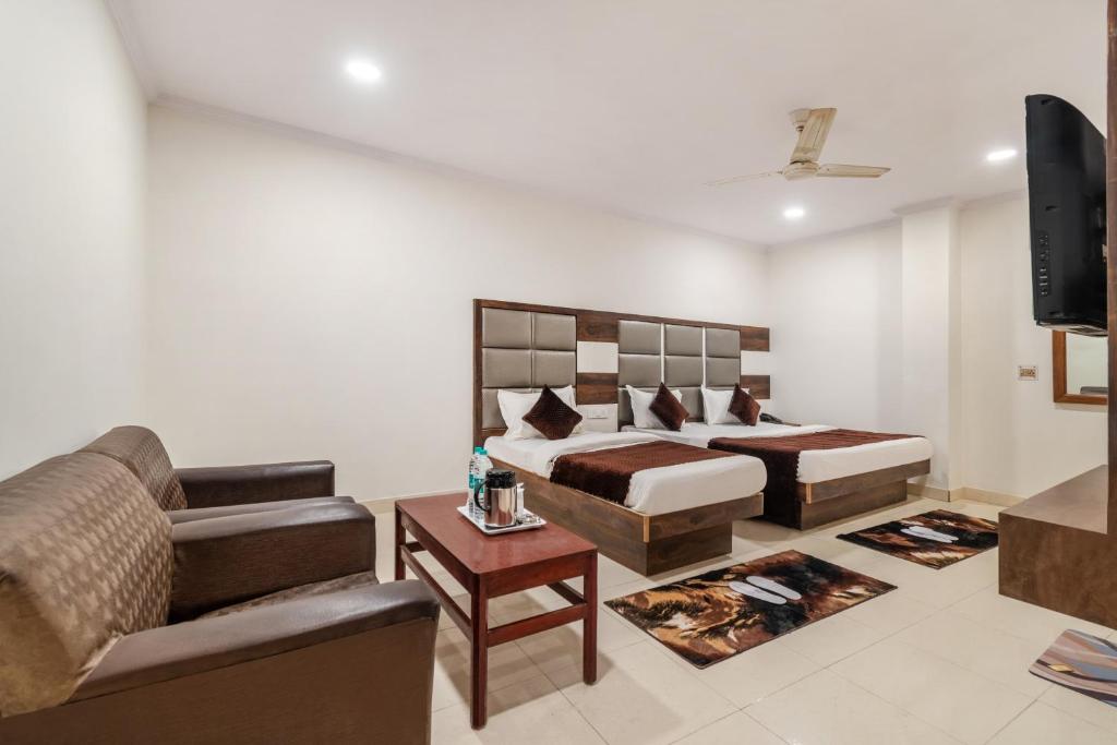 新德里Hotel South Indian的一间卧室配有一张床、一张沙发和一台电视