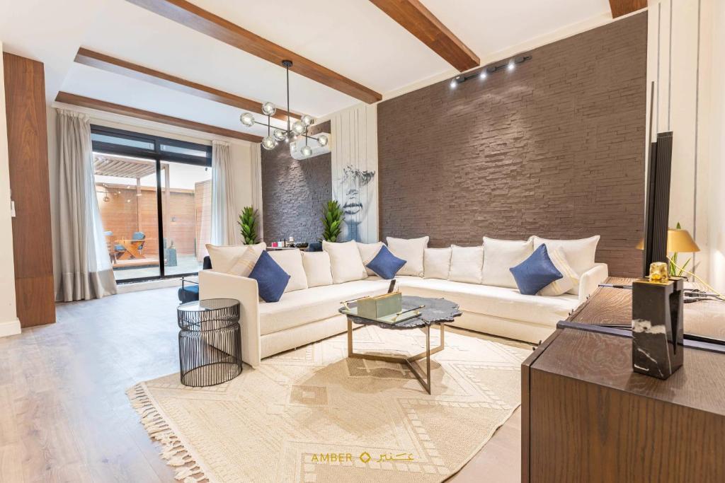 利雅德Amber Hospitality - Al Qairawan的客厅配有白色沙发和蓝色枕头。