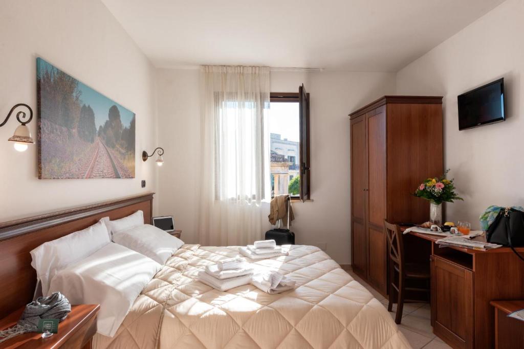 斯蓬加诺Relais Casina Copini的一间卧室配有一张床、一张书桌和一个窗户。