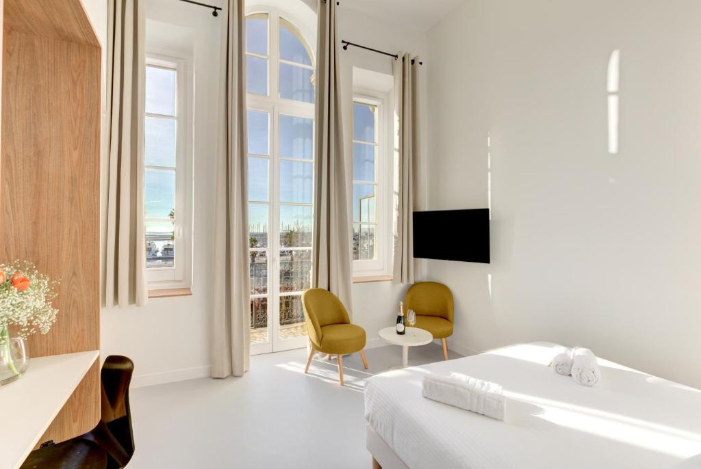 戛纳IMMOGROOM - Apparements luxueux - 2min du Palais - Vue mer - Clim的白色的客房设有床、浴缸和窗户。