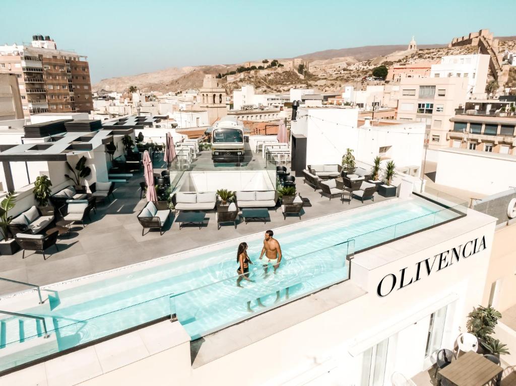 阿尔么丽亚HO Puerta de Purchena的两人在大楼顶部的游泳池里