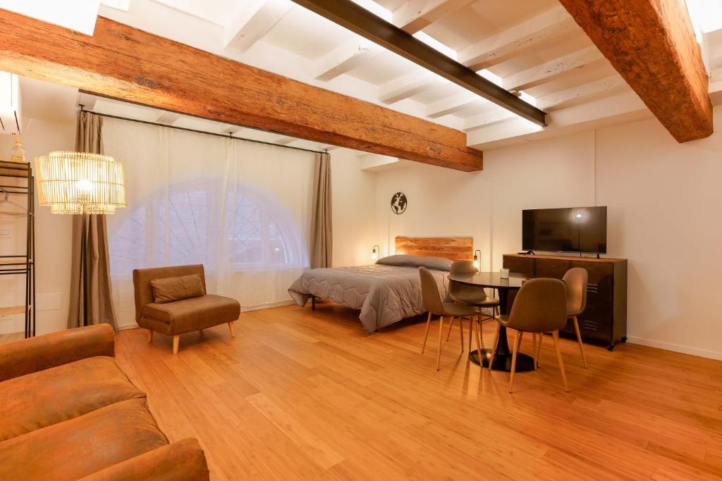 博洛尼亚Sette Chiese Apartments的一间卧室配有一张床、一张桌子和一张沙发