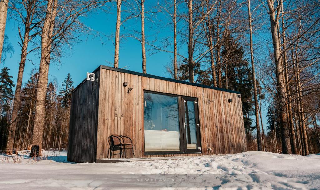 奥泰佩Juusa cabin的雪中带椅子的小小屋