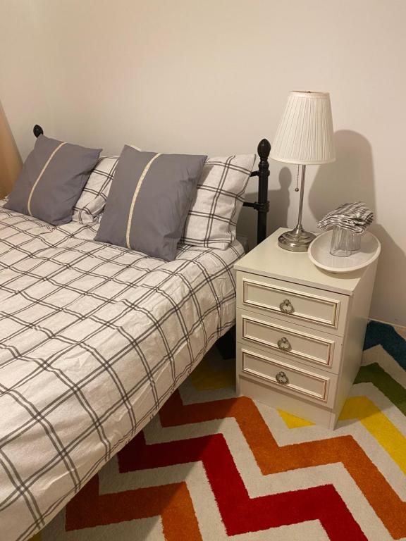 LexdenJmk home的一间卧室配有一张床和一个带灯的床头柜