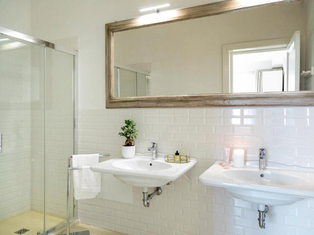 塔维亚诺Relais San Martino Salento - Handwritten Collection的白色的浴室设有两个盥洗盆和镜子