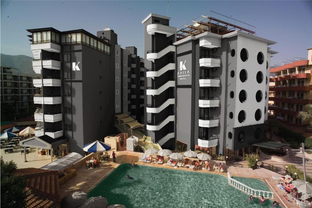 阿拉尼亚Kaila Krizantem Hotel的一座酒店,毗邻两座高楼,设有游泳池