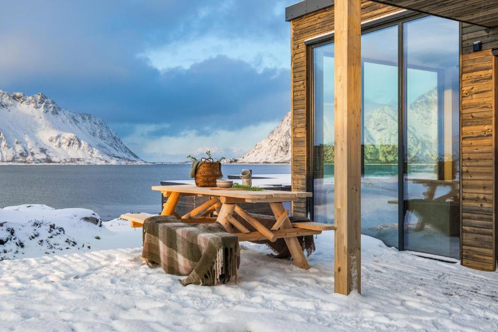 LyngværetNydelig hytte i unike Lofoten i nærheten av Henningsvær!的小木屋,配有雪地野餐桌