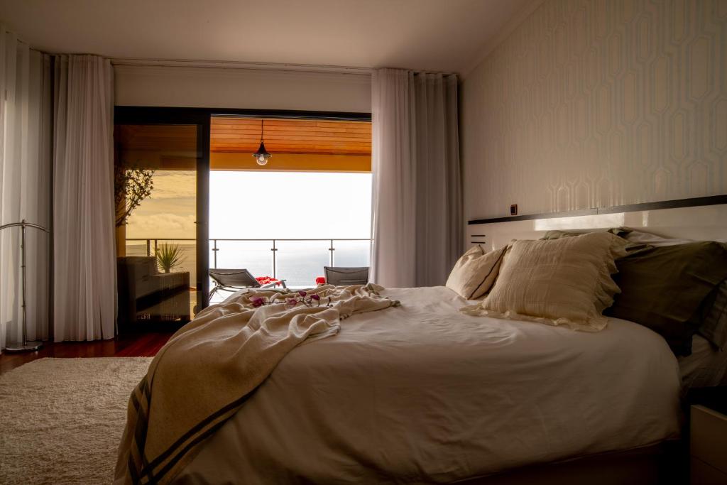 里韦拉布拉瓦Bairos House - Coastal Escape的卧室设有一张大白色的床和大窗户