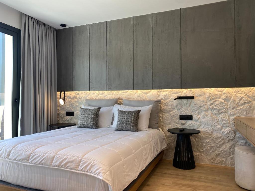 帕尔加Tramonto Maisonettes & Suites的卧室配有一张白色大床和墙壁