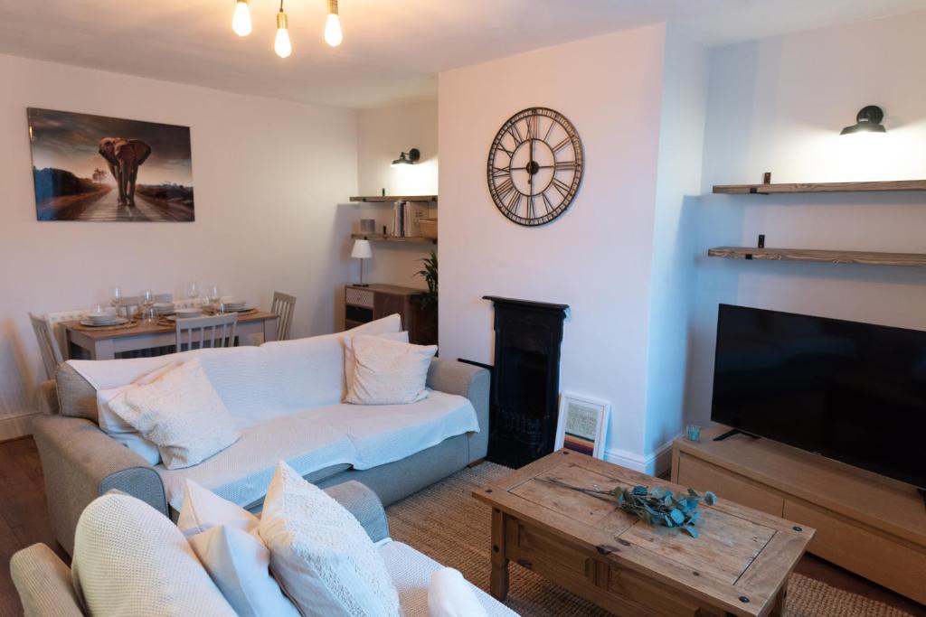 DeepcarOak Cottage的客厅配有沙发和墙上的时钟