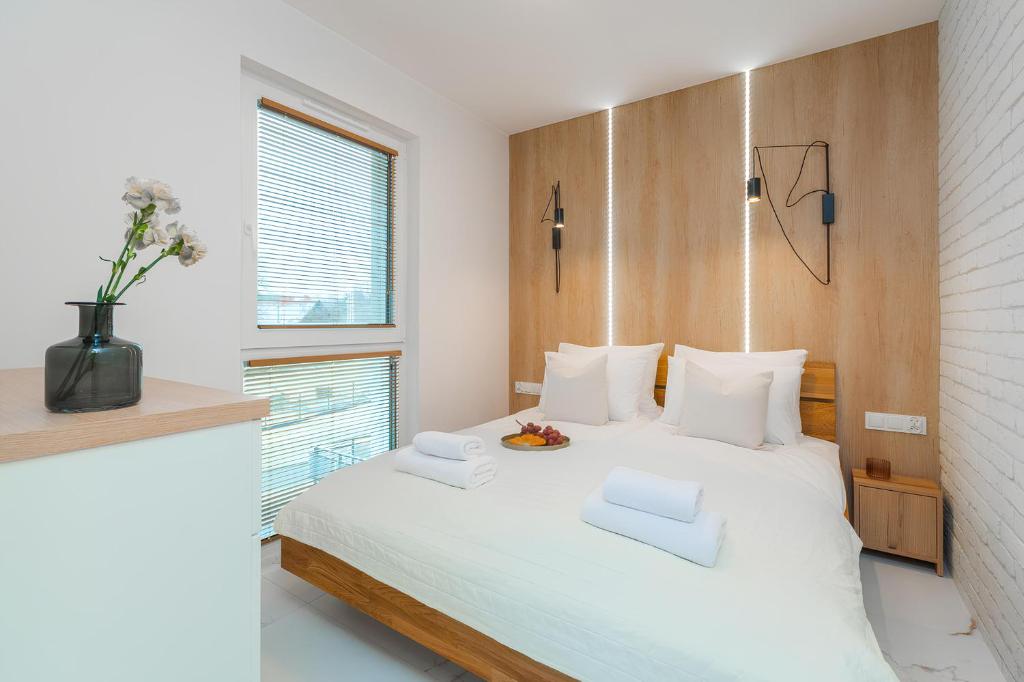 詹塔尔Flatbook Apartamenty - Jantar Resort的卧室配有白色的床和木制床头板