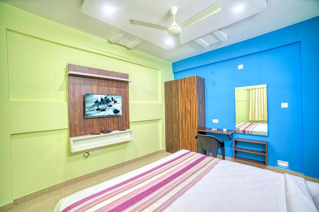 班加罗尔Redkey Transit Hotel Near Bangalore Airport的一间卧室拥有蓝色和绿色的墙壁,配有一张床