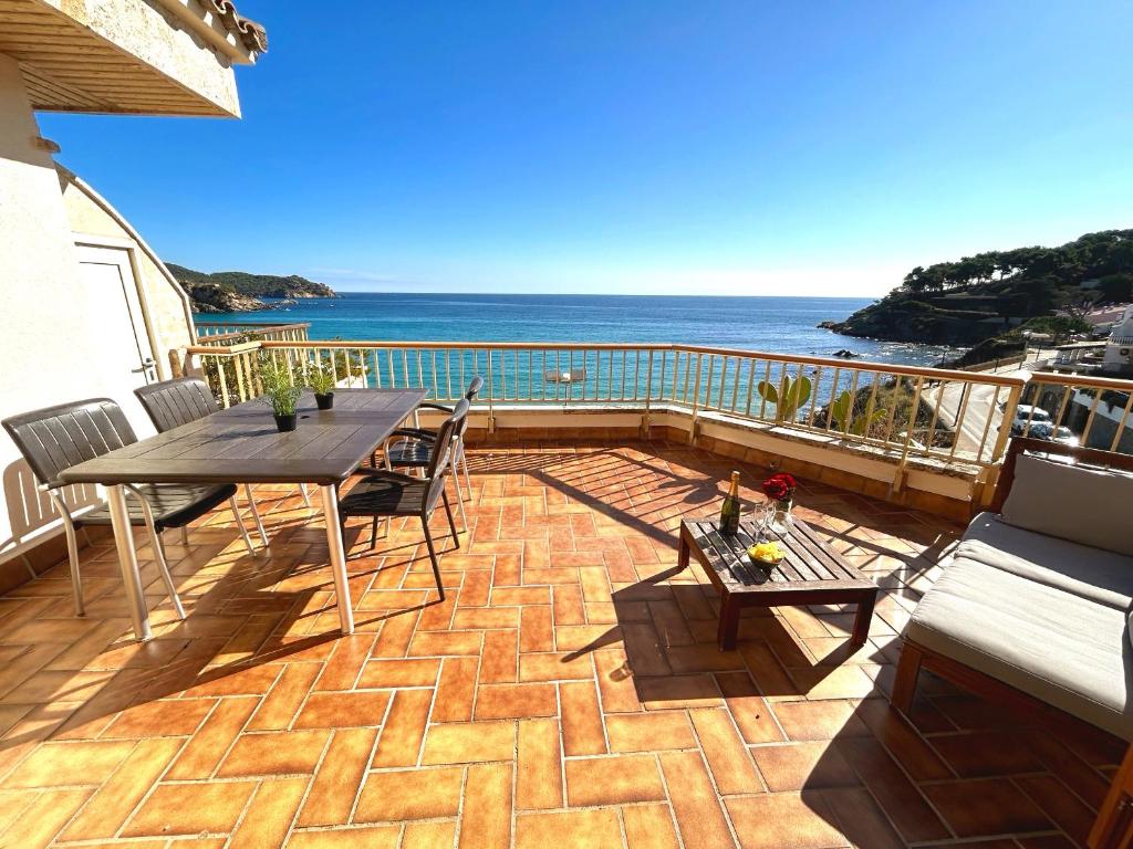 帕拉莫斯Charming apartment in La Fosca Beach的一个带桌椅的庭院和大海