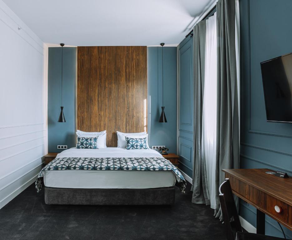 第比利斯Twenties Hotel的一间卧室配有一张蓝色墙壁的床