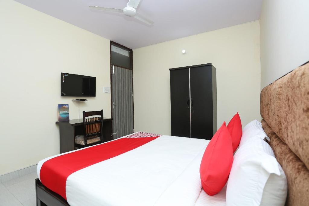 古尔冈OYO Hotel Awesome Villa Near Appu Ghar的一间卧室配有红色和白色枕头的床